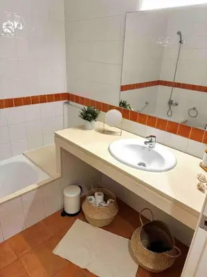 a bathroom with a sink and a tub and a mirror at Apartamento St Agustí - Centro in Mataró
