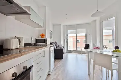 a kitchen with white cabinets and a counter top at Habitat Apartments Blanca in Barcelona