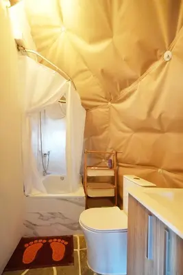 a bathroom with a toilet and a tub in a tent at AAA View Private Terrace Outdoor Heated Hot Tub Family Fun in Badalona