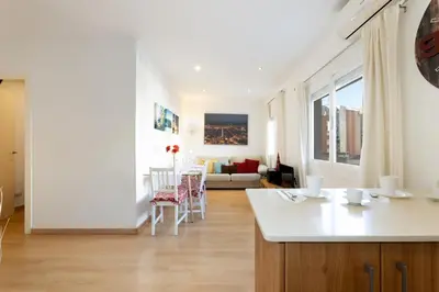 a kitchen and living room with a table and chairs at Cute Apartment in Sants Station with HBO & Alexa & AC in Barcelona