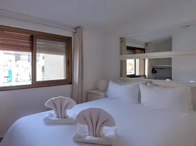 a white bedroom with two towels on a bed at Stay U-nique House Torre Damians in Barcelona