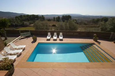 a swimming pool with two lawn chairs and a table at Catalunya Casas Indoor and Outdoor Pools, Sauna, Gym, Games Area in Sant Pau dʼOrdal