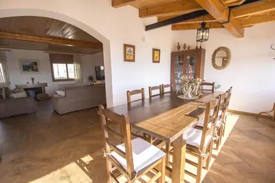 a dining room with a wooden table and chairs at Catalunya Casas Indoor and Outdoor Pools, Sauna, Gym, Games Area in Sant Pau dʼOrdal