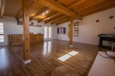 a large living room with wooden floors and a piano at Catalunya Casas Indoor and Outdoor Pools, Sauna, Gym, Games Area in Sant Pau dʼOrdal