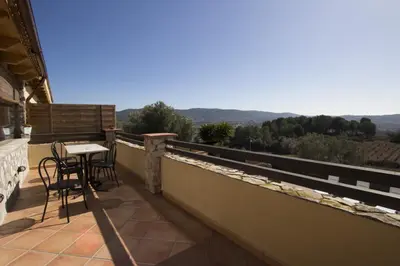 a balcony of a house with a table and chairs at Catalunya Casas Indoor and Outdoor Pools, Sauna, Gym, Games Area in Sant Pau dʼOrdal