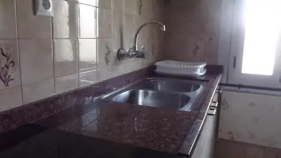 a kitchen with a stainless steel sink and a window at Apartamentos Atlas Terrassa I in Terrassa