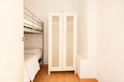 a white bedroom with a bed and a closet at Gothic - Ramblas Apartments in Barcelona