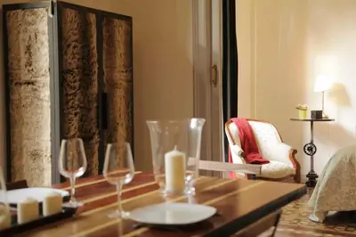 a room with a table with wine glasses and a chair at Rafael Music Palace apartment in Barcelona