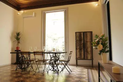 a dining room with a table and chairs and a window at Rafael Music Palace apartment in Barcelona