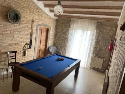 a room with a pool table in a room with a brick wall at Cal Tomaset in Les Cabanyes
