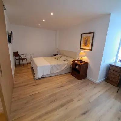 a bedroom with a bed and a table with a lamp at Ancora Apartment in Vilanova i la Geltrú
