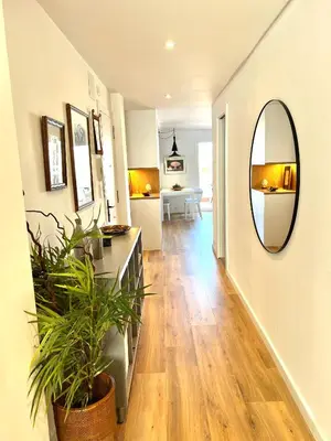 a hallway with a mirror and a potted plant at Ancora Apartment in Vilanova i la Geltrú