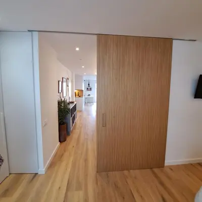 a wooden door in a room with a hallway at Ancora Apartment in Vilanova i la Geltrú