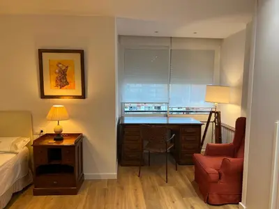 a bedroom with a desk and a bed and a chair at Ancora Apartment in Vilanova i la Geltrú