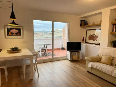 a living room with a couch and a table and a television at Ancora Apartment in Vilanova i la Geltrú