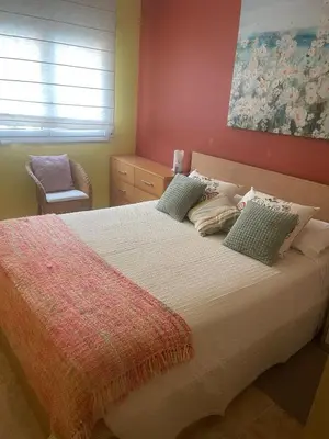 a bedroom with a large bed with green pillows at Cunit Beach in Cunit