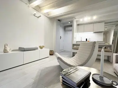 a bedroom with a bed with a large painting on the wall at White Apartment Barcelona in Barcelona