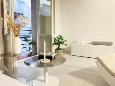 a living room with a table with a candle on it at White Apartment Barcelona in Barcelona