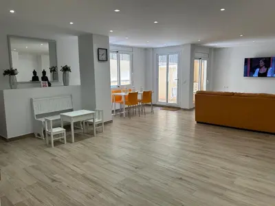 a lobby with a couch and a table and chairs at APARTAMENTO EN LA PLAYA in Pineda de Mar