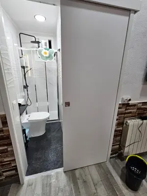 a bathroom with a door leading to a toilet at Habitación doble con baño privado in Hospitalet de Llobregat