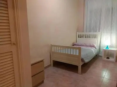 a small bedroom with a bed and a lamp at Glorias:Sagrada Familia 15 minutos - Playa 20 minutos in Barcelona