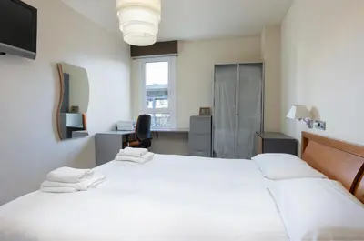 a bedroom with two beds and a desk and a window at Aparteasy - Bright, large and central apartment in BCN in Barcelona