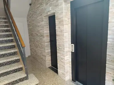 a staircase with a black door next to a brick wall at Apartament IXA-2 in Manresa