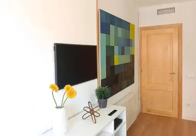 a living room with a television and a table with flowers at Comfortable apartment. Very central and quiet. in Barcelona
