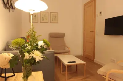 a living room with a vase of flowers on a table at Comfortable apartment. Very central and quiet. in Barcelona