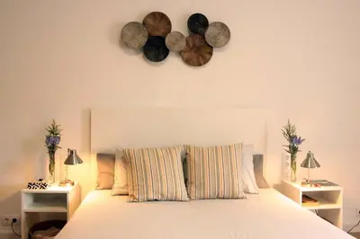 a bedroom with a bed with two tables and two hats on the wall at Comfortable apartment. Very central and quiet. in Barcelona