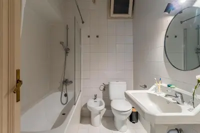 a white bathroom with a toilet and a sink at Canela Homes BARCELONA MODERNISTA in Barcelona