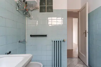 a blue tiled bathroom with a toilet and a sink at Canela Homes BARCELONA RAMCAT37 in Barcelona