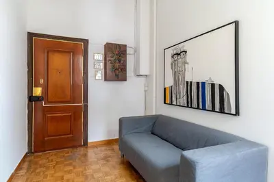 a living room with a blue couch and a door at Canela Homes BARCELONA RAMCAT37 in Barcelona