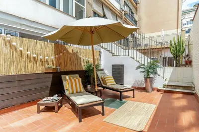 a patio with two chairs and an umbrella at Canela Homes BARCELONA ART in Barcelona