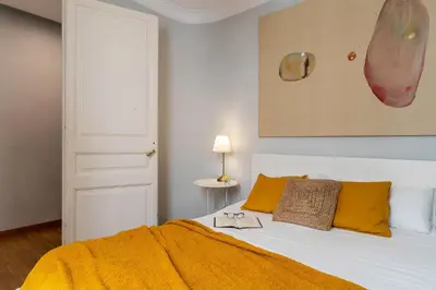 a bedroom with a white bed with yellow pillows at Canela Homes BARCELONA DIPUTACIÓ in Barcelona
