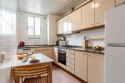 a kitchen with white cabinets and a white refrigerator at Canela Homes BARCELONA DIPUTACIÓ in Barcelona
