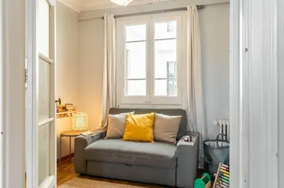 a gray chair with a yellow pillow in a room at Canela Homes BARCELONA DIPUTACIÓ in Barcelona