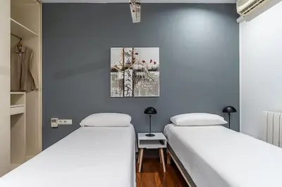 two beds in a room with blue walls at Canela Homes BARCELONA ARAGÓ in Barcelona