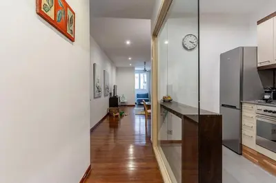 a kitchen with a counter and a clock on the wall at Canela Homes BARCELONA ARAGÓ in Barcelona