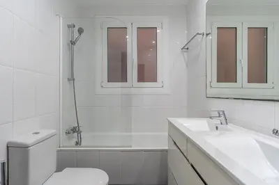 a white bathroom with a toilet and a sink at Canela Homes BARCELONA ROSSELLÓ in Barcelona