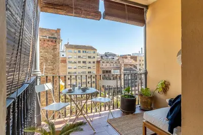 a balcony with a table and chairs and a large window at Canela Homes BARCELONA VLC306 in Barcelona