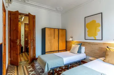 a hotel room with two beds and a door at Canela Homes BARCELONA VLC306 in Barcelona