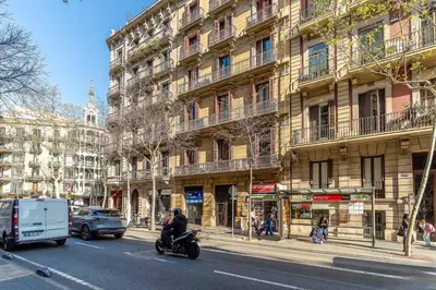 a man riding a motorcycle down a street next to a building at Canela Homes BARCELONA VLC306 in Barcelona