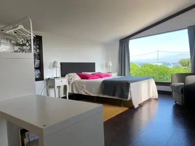 a bedroom with a bed and a large window at LOFT CAL XURIGUER in Font-Rubí