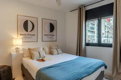 a bedroom with a large bed with a window at Canela Homes BARCELONA NINOT in Barcelona