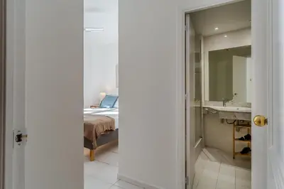 a bedroom with a bed and a sink and a mirror at Canela Homes BARCELONA NINOT in Barcelona