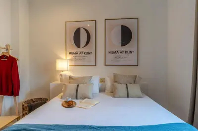 a bedroom with a bed with three pictures on the wall at Canela Homes BARCELONA NINOT in Barcelona