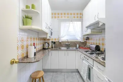 a white kitchen with white cabinets and a sink at Canela Homes BARCELONA PARK GÜELL in Barcelona