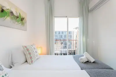 a bedroom with a large white bed with a window at Canela Homes BARCELONA COZY in Barcelona
