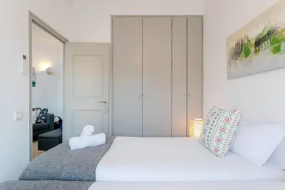 a bedroom with a white bed with a large white bedspread at Canela Homes BARCELONA COZY in Barcelona